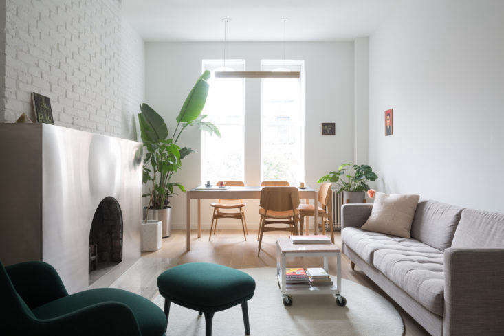 The front living area, after, is white-washed and bright, with minimal furnishings that emphasize the height of the ceilings. A coffee table on wheels allows for flexibility in the small space.