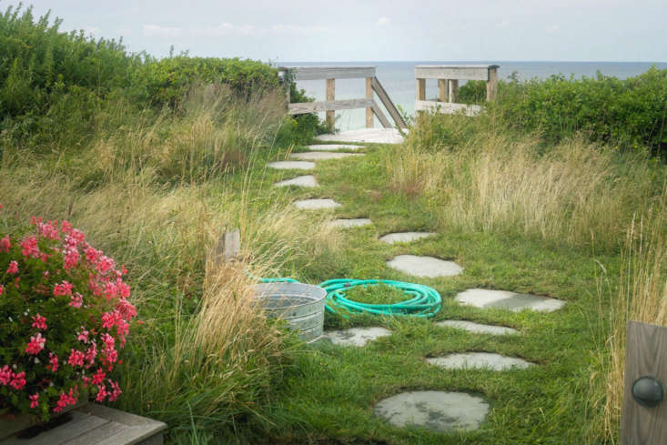At Merryfield Cottage in Truro, Massachusetts, owners Steve Corkin and Dan Maddalena installed a convenient rinsing station, including hose and water-filled bucket, beside the beach path. See Tales from Truro: An Untamed Landscape Channels Thoreau’s Cape Cod.