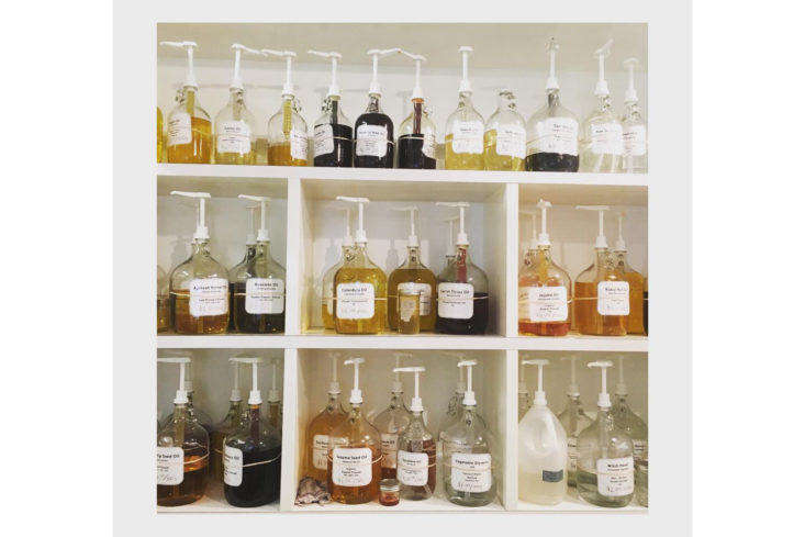 Skin oils ready to be dispensed at the store, including sea buckthorn oil, camellia tea oil, rose hip seed oil, and jojoba oil.